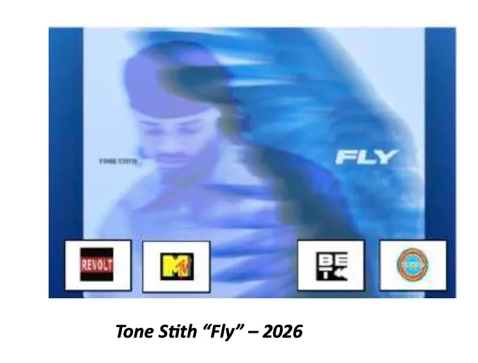Still from Tone Stith's music video Fly — a motion-blurred blue-toned shot of the artist in a beanie with streaking light trails, the word FLY in white type.